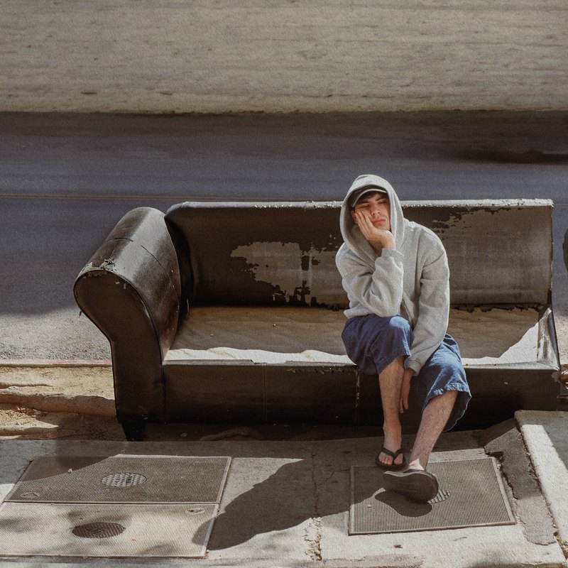 wasteland cover: bana on a couch left out on the sidewalk